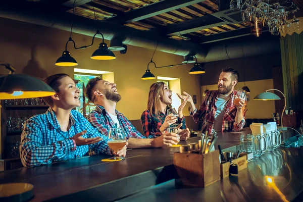 Sport, mensen, vrije tijd, vriendschap en entertainment concept - gelukkig voetbalfans of mannelijke vrienden drinken bier en vieren overwinning bij bar of pub — Stockfoto