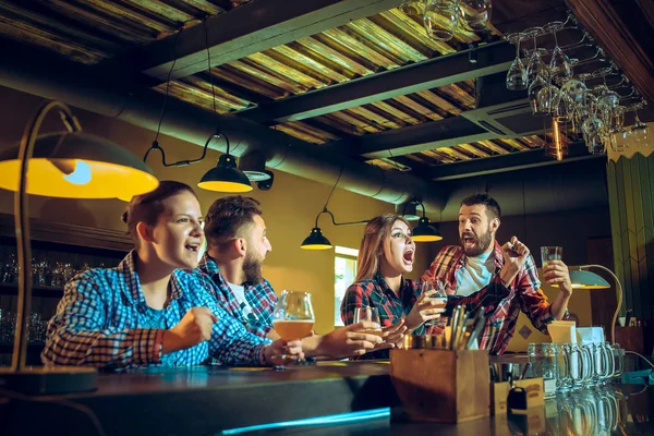 Sport, mensen, vrije tijd, vriendschap en entertainment concept - gelukkig voetbalfans of mannelijke vrienden drinken bier en vieren overwinning bij bar of pub — Stockfoto