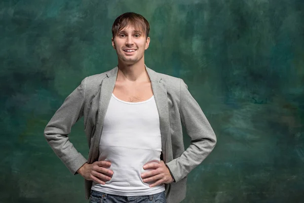 L'uomo felice in piedi e sorridente sullo sfondo dello studio . — Foto Stock