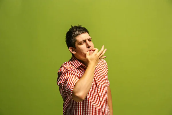 Eristetty vihreä nuori rento mies huutaa studiossa — kuvapankkivalokuva