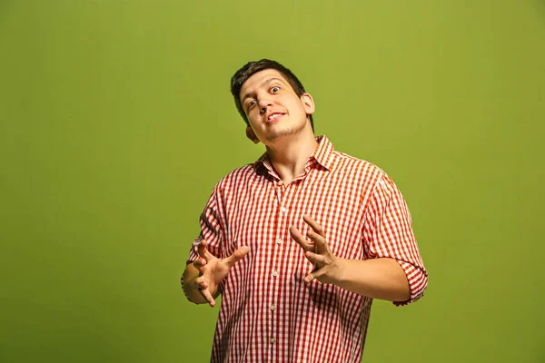 Młody człowiek zły emocjonalne krzyczy na tle zielonej studio — Zdjęcie stockowe