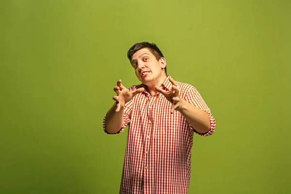O jovem homem irritado emocional gritando no fundo do estúdio verde — Fotografia de Stock