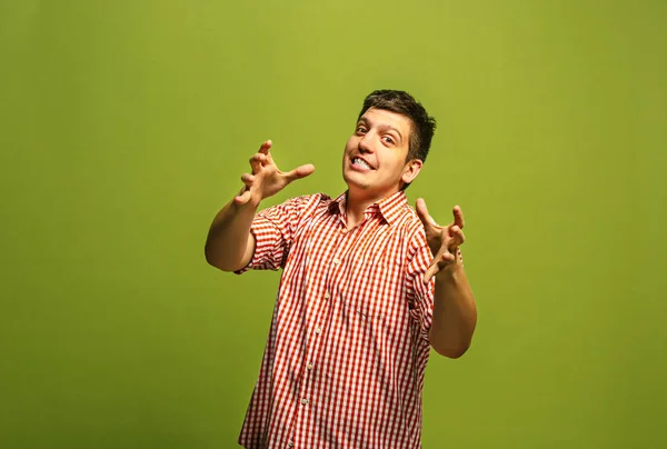 El joven hombre enojado emocional gritando en el fondo del estudio verde — Foto de Stock