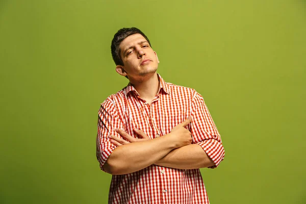 Let me think. Doubtful pensive man with thoughtful expression making choice against green background