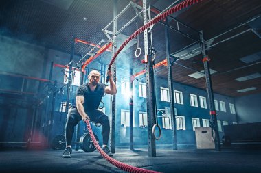 Savaş ip savaş ipleri egzersiz fitness salonunda erkeklerle.