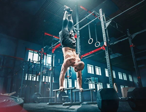 Kavram: Güç, güç, sağlıklı yaşam tarzı, spor. CrossFit spor salonundaki güçlü çekici kaslı adam.