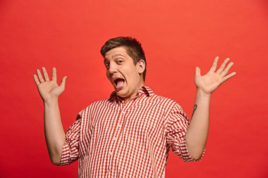 Ben kazandım. Bir kazanan olmak kutluyor kazanan başarı mutlu bir adam. Dinamik görüntü kırmızı studio arka plan üzerinde beyaz erkek modeli. Zafer, zevk kavramı. İnsan yüz duyguları kavramı. Trendy renkler