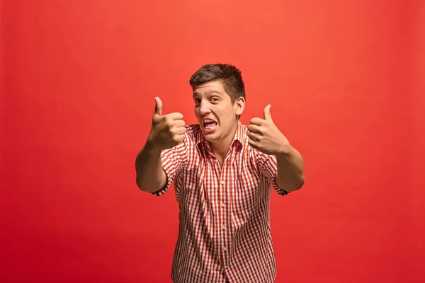 El hombre de negocios feliz de pie y sonriendo sobre el fondo rojo . — Foto de Stock