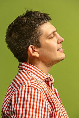 Ayakta ve yeşil arka planı gülümseyen mutlu iş adamı.