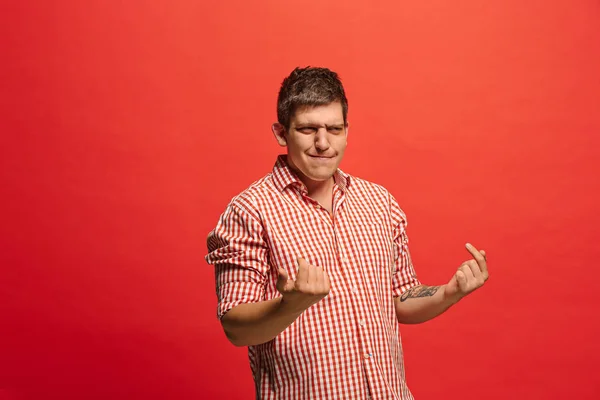 Beautiful male half-length portrait isolated on red studio backgroud. The young emotional surprised man