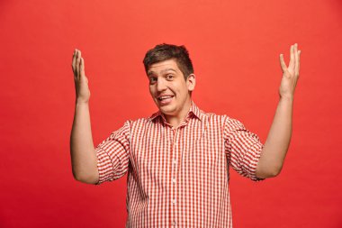 Şaşırmış görünen çekici adam izole kırmızı genç