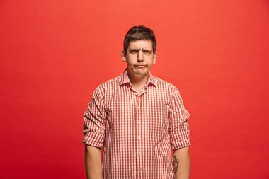 İzole kırmızı studio kağıt üzerinde güzel erkek varoluş portre. Genç duygusal şaşırmış adam