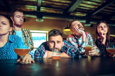 Üzgün spor oyun ya da futbol maçı izlerken ve bira içme ve erkek arkadaş bar veya pub.