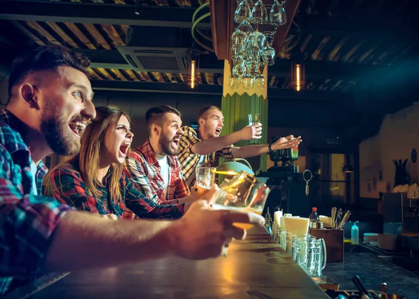 Olahraga, orang, waktu luang, persahabatan dan konsep hiburan - penggemar sepak bola yang bahagia atau teman laki-laki minum bir dan merayakan kemenangan di bar atau pub — Stok Foto