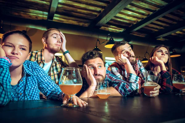 Streek van mannelijke en vrouwelijke vrienden kijken naar sport spel of voetbalwedstrijd en drinken bier bij bar of pub. — Stockfoto