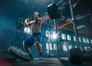 Genç adam bir spor salonunda egzersiz Barbell kaldırma uygun