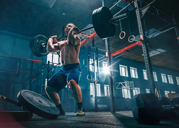 Fit jonge man tillen halters trainen in een sportschool — Stockfoto