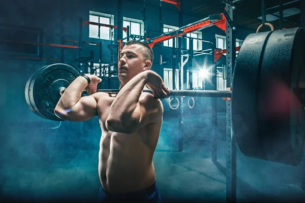 Ajuste joven levantando barras de entrenamiento en un gimnasio —  Fotos de Stock