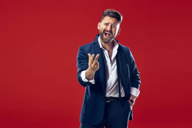 İzole kırmızı studio kağıt üzerinde güzel erkek varoluş portre. Genç duygusal şaşırmış adam