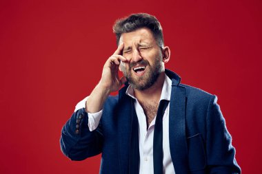 Baş ağrısı olan adam. Kırmızı arka plan üzerinde izole.