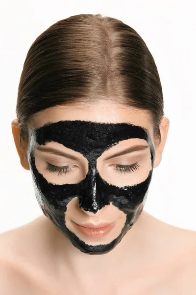 Jonge mooie vrouw een masker voor het gezicht van de therapeutische zwarte modder toe te passen. Spa-behandeling — Stockfoto