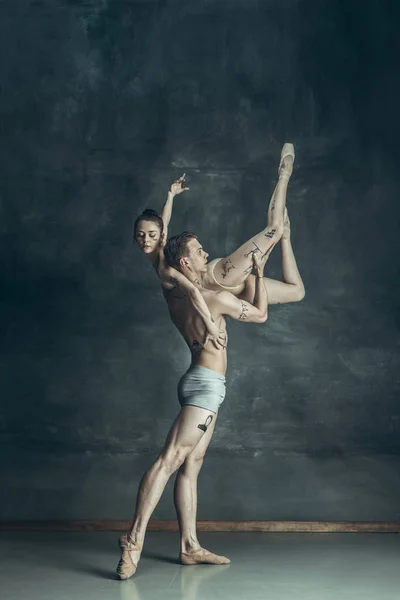 Os jovens bailarinos modernos posando no fundo do estúdio cinza — Fotografia de Stock