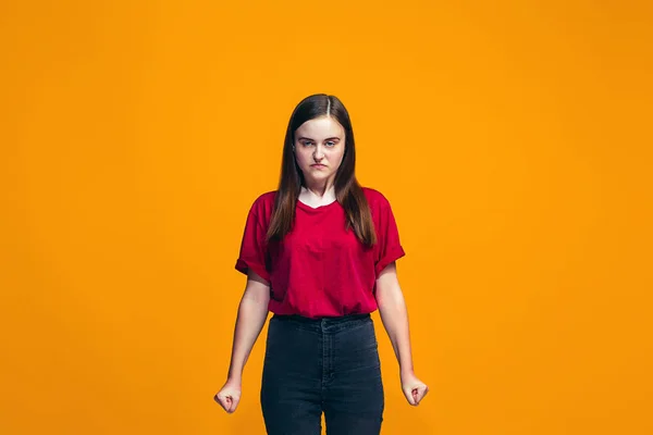 Turuncu studio arka plan üzerinde kızgın genç kız portresi — Stok fotoğraf