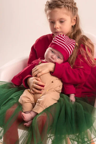 Happy little teen girl holding his newborn baby little sister. Family love. — Stock Photo, Image