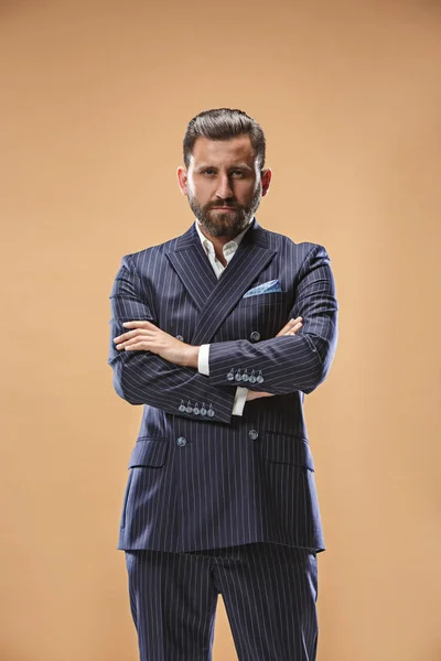 Conceito de beleza masculina. Retrato de um jovem elegante com corte de cabelo elegante vestindo terno na moda posando sobre fundo pastel . — Fotografia de Stock