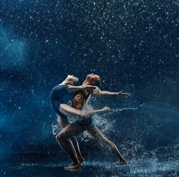 Giovane coppia di ballerini che ballano unde rwater drops — Foto Stock