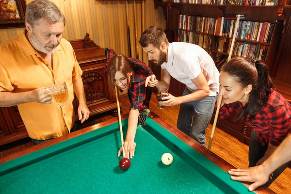 Hombres y mujeres jóvenes jugando billar en la oficina después del trabajo . —  Fotos de Stock