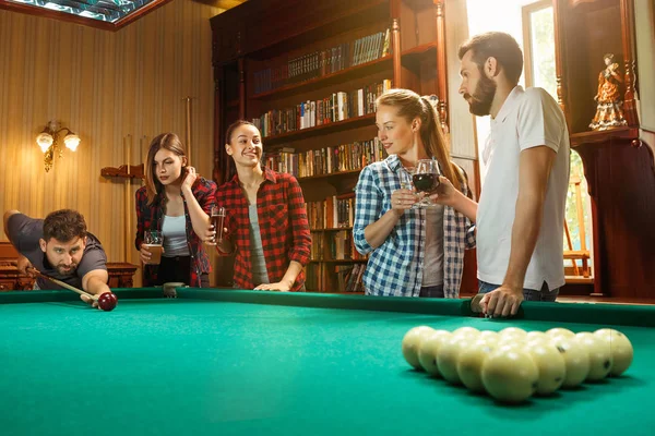 Hombres y mujeres jóvenes jugando billar en la oficina después del trabajo . — Foto de Stock