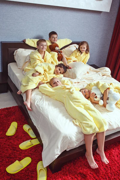 Large group of friends taking goog time on bed — Stock Photo, Image