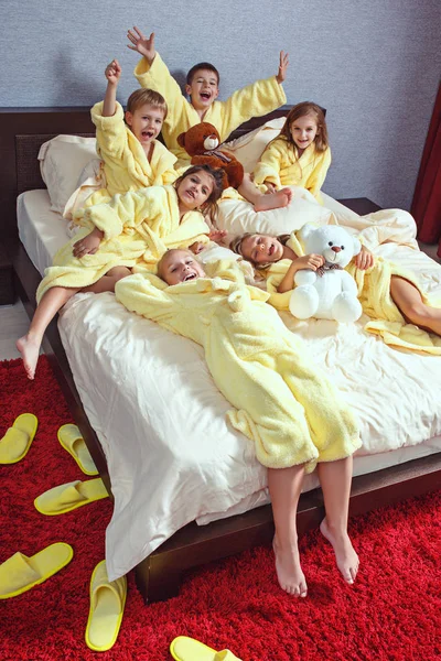 Large group of friends taking goog time on bed — Stock Photo, Image