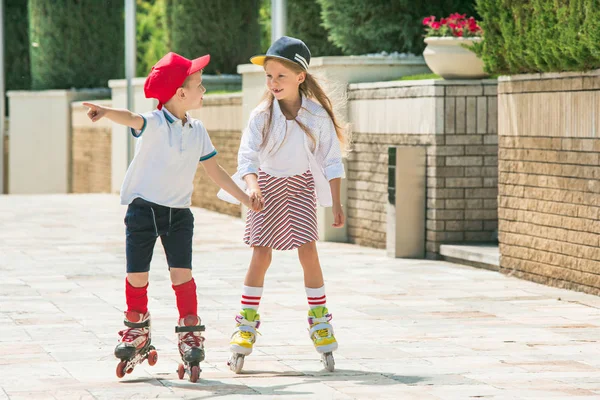 Retrato de um casal adolescente encantador patinação em patins juntos — Fotografia de Stock