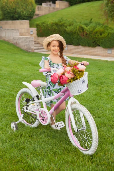 Красивая маленькая девочка на велосипеде через парк. Природа, образ жизни — стоковое фото