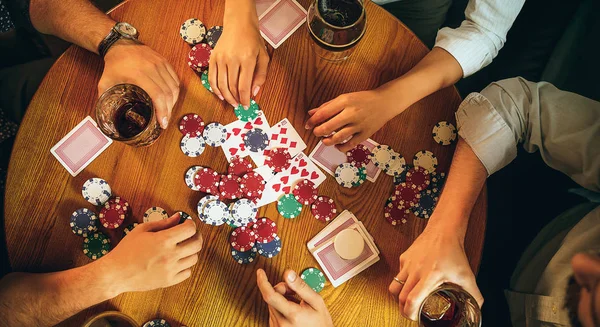 Foto vista superior de amigos sentados à mesa de madeira. Amigos se divertindo enquanto joga jogo de tabuleiro . — Fotografia de Stock