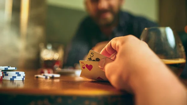 Foto vista lateral de amigos sentados à mesa de madeira. Amigos se divertindo enquanto joga jogo de tabuleiro . — Fotografia de Stock