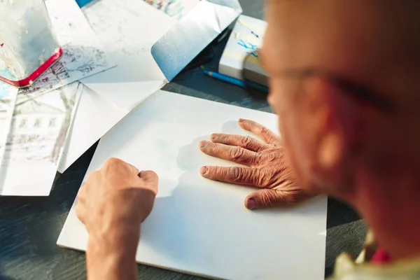 Primer plano del hombre que trabaja de Arquitecto bosquejando un proyecto de construcción en su proyecto de avión en obras de construcción de obra — Foto de Stock