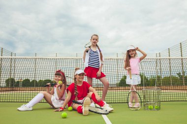 Kız tenis oyuncular tenis raketi açık kortu yeşil çim karşı holding olarak grup portresi