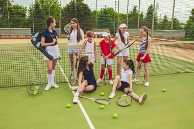 Kız tenis oyuncular tenis raketi açık kortu yeşil çim karşı holding olarak grup portresi