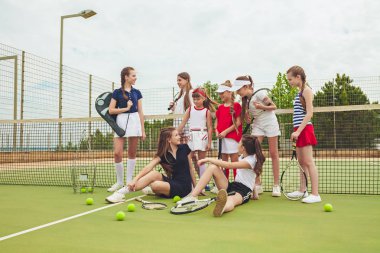 Kız tenis oyuncular tenis raketi açık kortu yeşil çim karşı holding olarak grup portresi