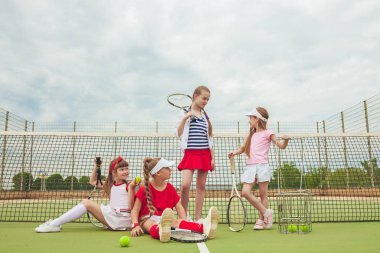 Kız tenis oyuncular tenis raketi açık kortu yeşil çim karşı holding olarak grup portresi
