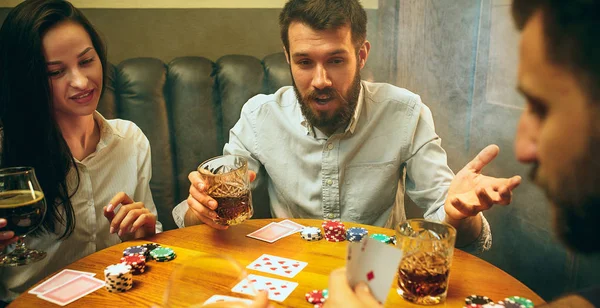 Vue de côté photo d'amis assis à la table en bois. Amis avoir du plaisir tout en jouant jeu de société . — Photo