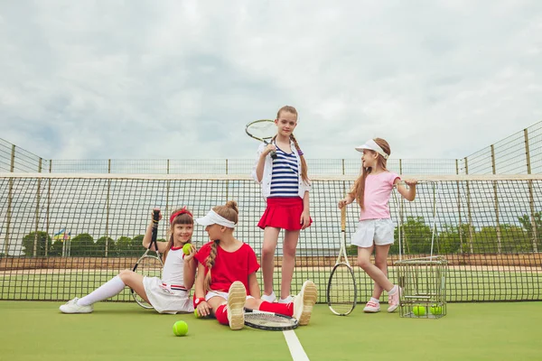 Portret van groep van meisjes als tennisspelers houden tennisracket tegen groen gras van buiten Hof — Stockfoto