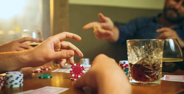 Foto vista lateral de amigos sentados à mesa de madeira. Amigos se divertindo enquanto joga jogo de tabuleiro . — Fotografia de Stock