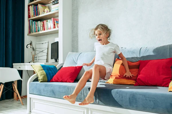 Piccolo sorpreso teen ragazza guardando la tv a casa . — Foto Stock