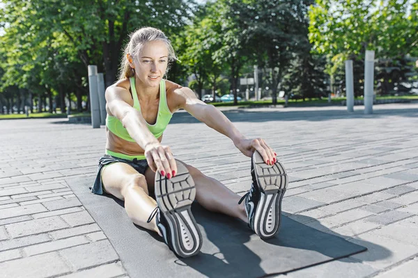 Fit mujer fitness haciendo ejercicios de estiramiento al aire libre en el parque —  Fotos de Stock