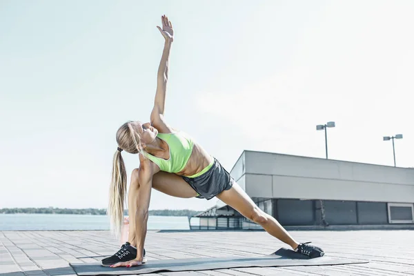 Fit mujer fitness haciendo ejercicios de estiramiento al aire libre en el parque —  Fotos de Stock