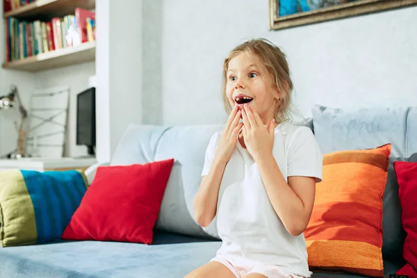 Μικρή έκπληξη έφηβος κορίτσι βλέποντας τηλεόραση στο σπίτι. — Φωτογραφία Αρχείου
